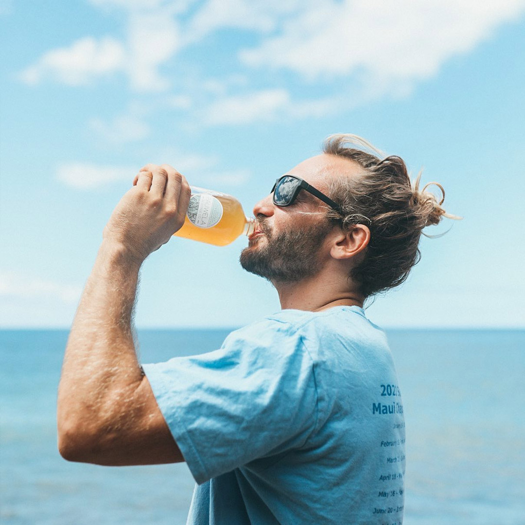 Maui Surfrider volunteer enjoying a sponsored beverage at a beach cleanup